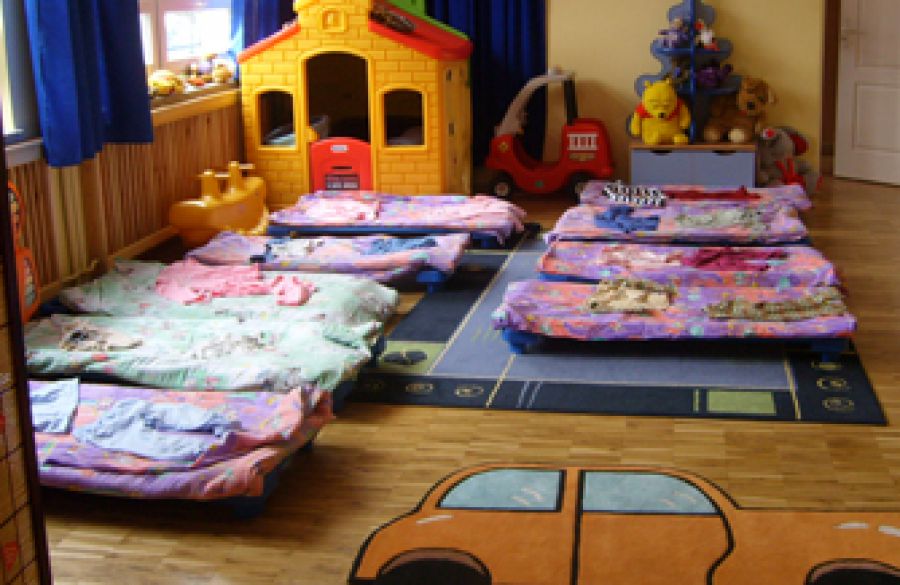 Sypialnia maluszków z leżakami z kolorową pościelą. 