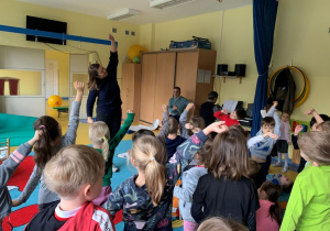 Dzieci uczestnią w koncercie muzycznym i naśladują ruchy muzyka.