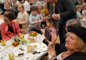 Dzień Babci i Dziadka- dzieci świetują z babcią i dziadkiem przy poczęstunku.