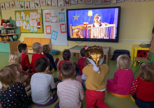 Dzieci siedzą i oglądają teatrzyk.