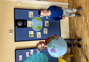 Chłopcy prezentuje globus oraz dobre zachowania dla Ziemi.