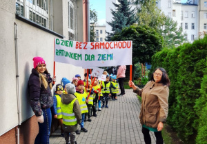 Panie nauczycielki trzymają baner zrobiony na dzień bez samochodu.