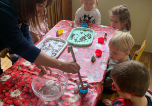 Pani nalewa dzieciom glicerynę do foremek.