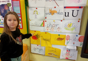 Dziewczynka wskazuje wyraz z literą "u".