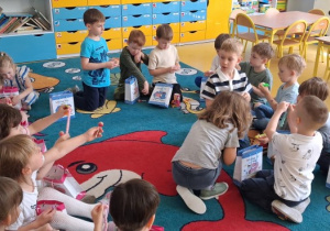 Urodziny. Dzieci oglądają upominki, które dostały od jubilata.
