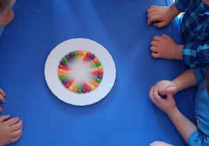 Dzieci obserwują jak rozpuszczają się cukierki.