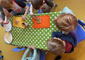 Dzieci smarują wafelki maską kajmakową.