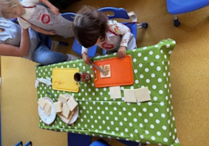 Dzieci smarują wafelki maską kajmakową.