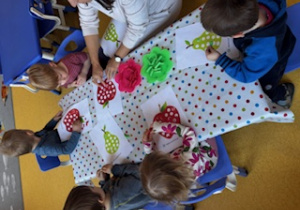 Dzieci uzupełniają plasteliną kolorowe jabłka i gruszki.