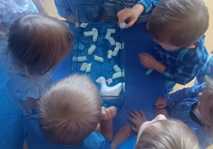 Dzieci wrzucają do wody styropianowe pianki.