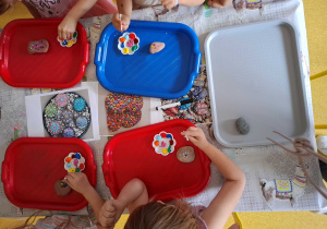 Dzieci malują kamienie według własnego pomysłu