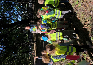 Dzieci na spacerze w parku uczestniczą w warsztatach o drzewach