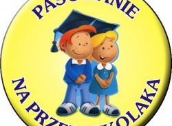 Dzieci stoją z biretami na głowach.