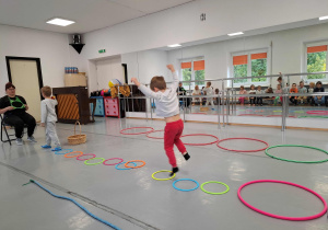 Logohulanki- dzieci skaczą przez obręcze.