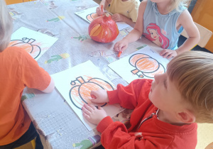 Dzieci kolorują dynie.