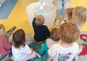 Dzieci obserwują co dzieje się z pianką w słoiku.