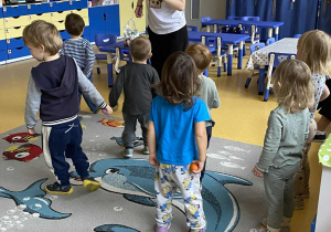 Dzieci stoją przed panią nauczycielką.