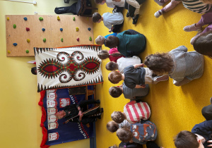 Dzieci oglądają koc pokazywany przez muzyka.