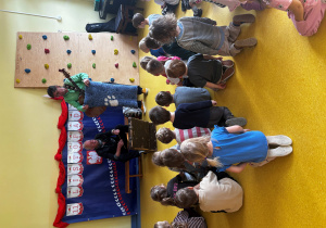 Dzieci oglądają dywanik pokazywany przez muzyka.