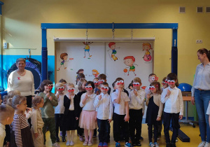 Dzieci stoją i trzymają biało czerwone okulary.