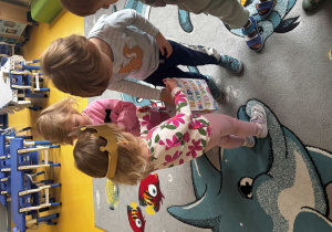 Dziewczynka rozdaje dzieciom prezenty.