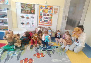 Dzieci pokazują misie do zdjęcia.