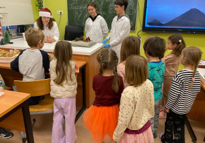 Eksperymenty w szkole, dzieci obserwują doświadczenie z ogniem.