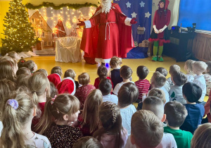 Święty Mikołaj wita się z dziećmi.