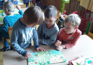 Dzieci grają w grę planszową.
