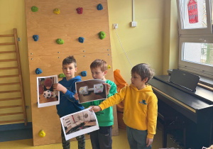 Chłopcy prezentują zdjęcia swoich prac konkursowych.